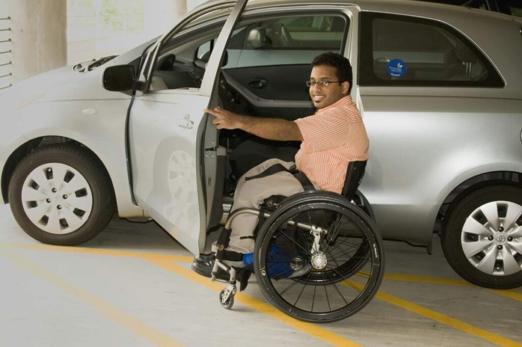 Man i rullstol på väg in i sin bil.